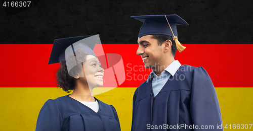 Image of happy students or bachelors in mortar boards