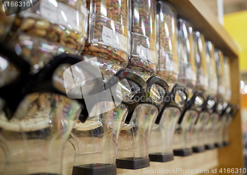 Image of row of jars with nuts and seeds at grocery store