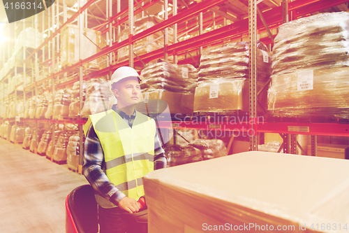 Image of man on forklift loading cargo at warehouse