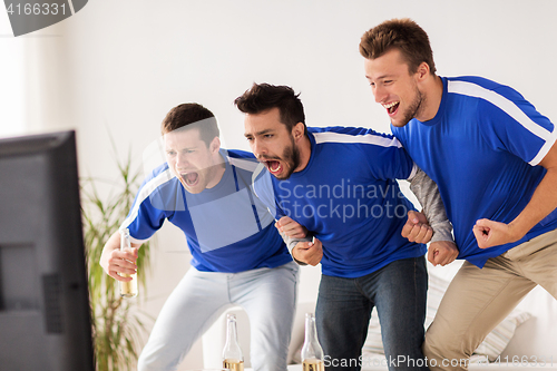 Image of friends or football fans watching soccer at home