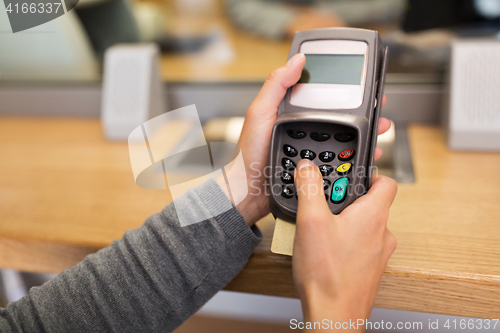 Image of hand entering pin code to card reader terminal