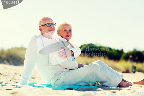 Image of happy senior couple hugging on summer beach