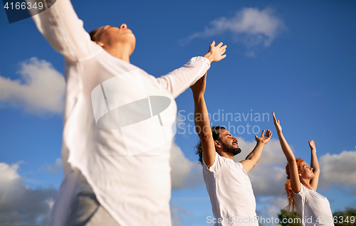 Image of group of people making yoga or meditating outdoors