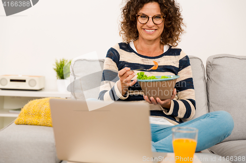 Image of Beautiful woman eating a salad