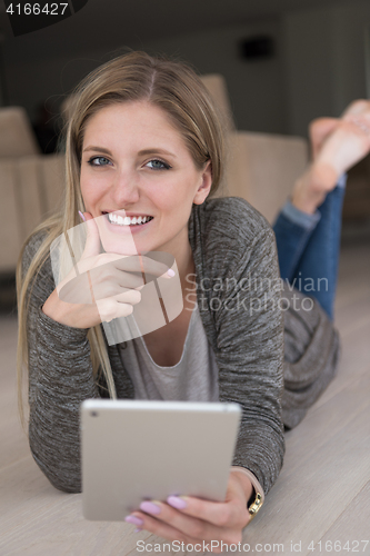 Image of young women used tablet computer on the floor