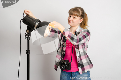 Image of Photographer studio sets reflector on monoblock flash