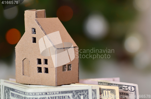 Image of Miniature paper made house stand on  money