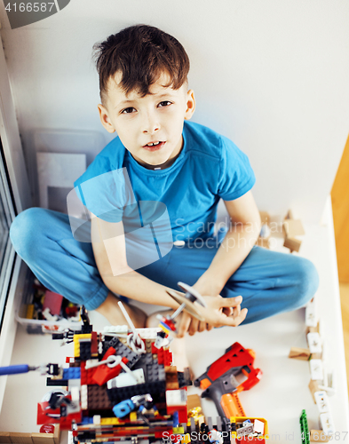 Image of little cute preschooler boy playing lego toys at home happy smil