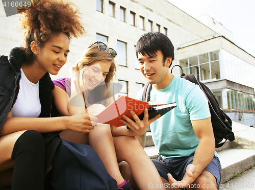 Image of cute group of teenages at the building of university with books huggings, back to school