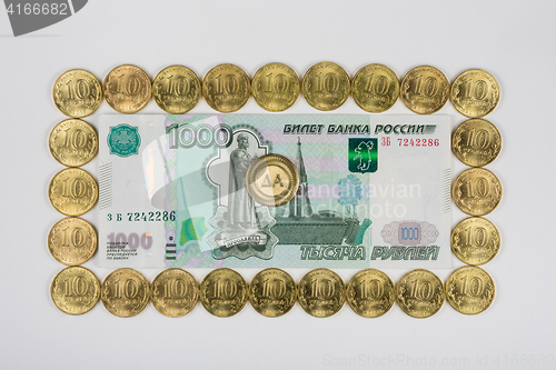 Image of Russian thousandth banknote lined the perimeter of a ten coins in the middle of the coin is a \"Yes\" sign