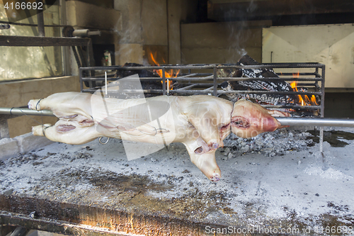 Image of Roasting suckling pig on the broach in the coals