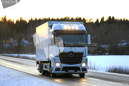 Image of White Mercedes-Benz Actros Trucking at Sunset
