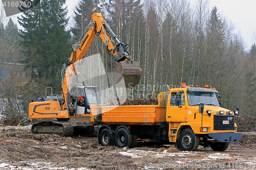 Image of Crawler Excavator Loads Sisu Tipper Truck
