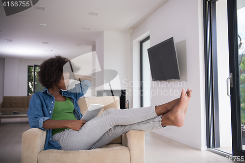 Image of african american woman at home with digital tablet