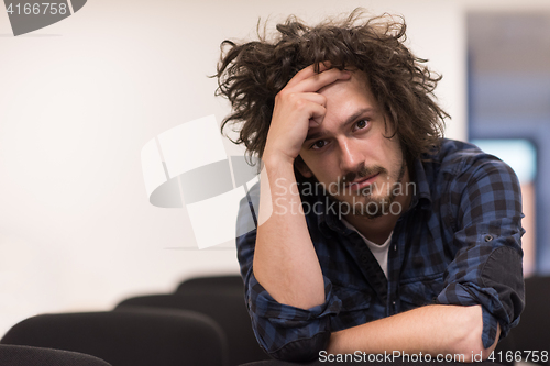 Image of A student sits alone  in a classroom