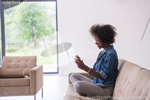 Image of african american woman at home with digital tablet