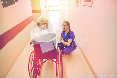 Image of nurse with senior woman in wheelchair at hospital