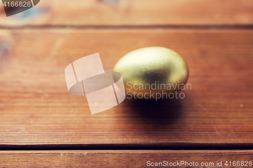 Image of close up of golden easter egg on wood