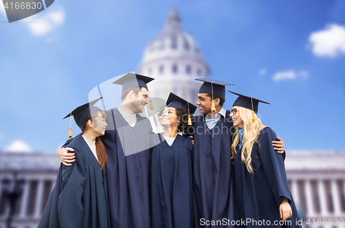 Image of happy students or bachelors in mortar boards