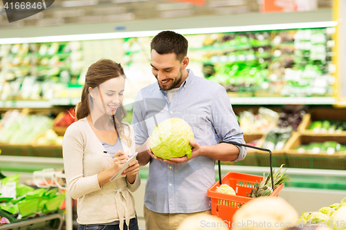 Image of couple with food basket shopping at grocery store