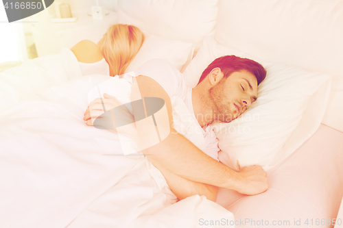 Image of couple sleeping in bed at home