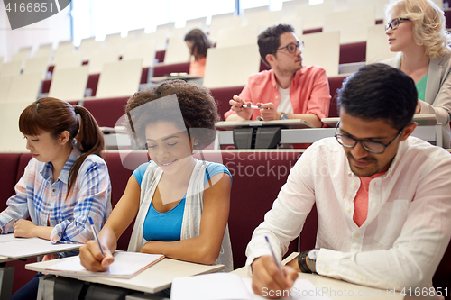 Image of group of students with notebooks in lecture hall