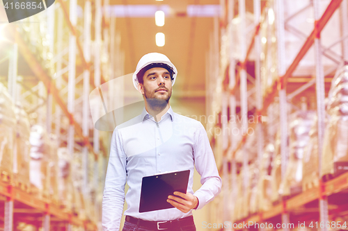 Image of happy businessman with clipboard at warehouse