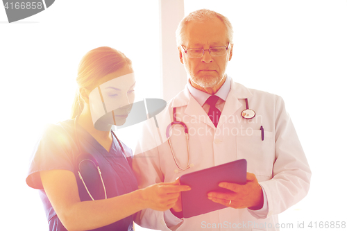 Image of senior doctor and nurse with tablet pc at hospital