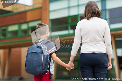 Image of elementary student boy with mother at school yard