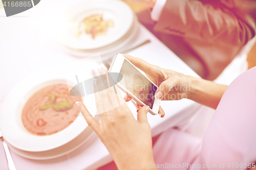 Image of close up of couple with smartphones at restaurant