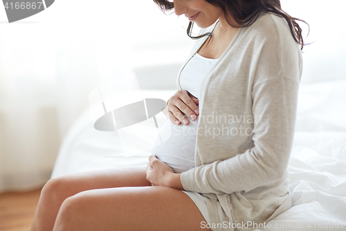 Image of close up of happy pregnant woman in bed at home