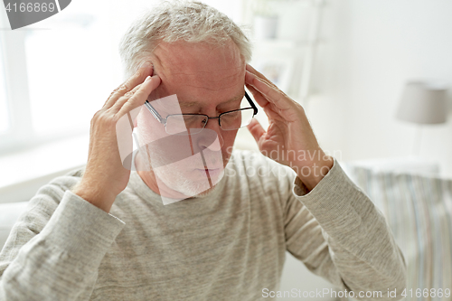 Image of senior man suffering from headache at home