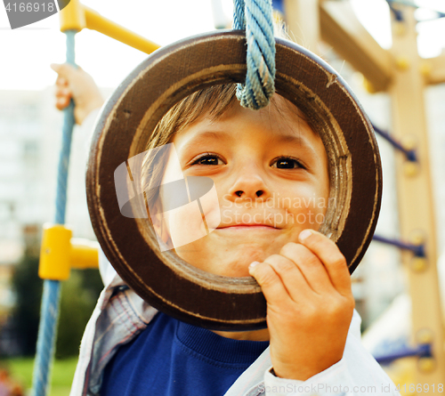 Image of little cute boy hanging on gymnastic ring