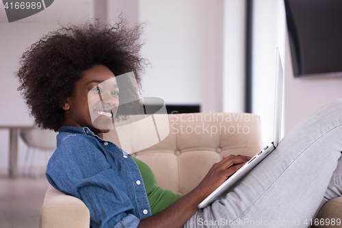 Image of African American women at home in the chair using a laptop