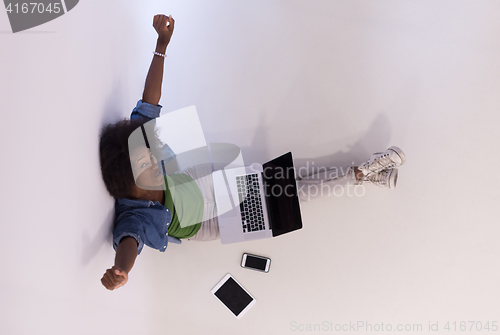 Image of african american woman sitting on floor with laptop top view