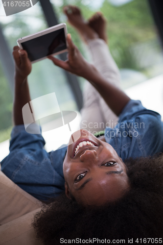 Image of african american woman at home with digital tablet