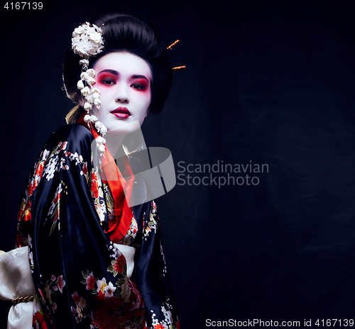 Image of young pretty geisha in kimono with sakura and decoration