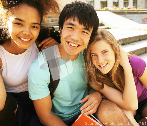 Image of cute group of teenages at the building of university with books huggings, back to school