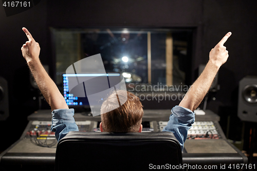 Image of man at mixing console in music recording studio