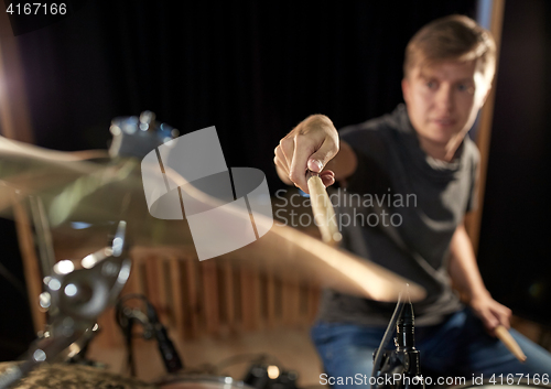 Image of male musician playing drums and cymbals at concert