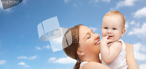 Image of happy mother holding adorable baby over blue sky