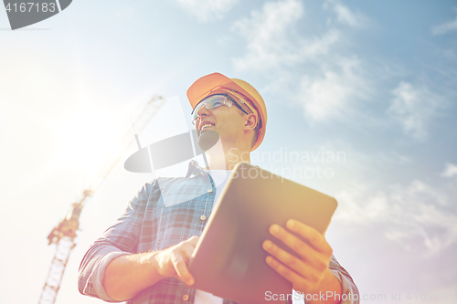 Image of builder in hardhat with tablet pc at construction