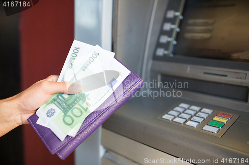 Image of close up of hand withdrawing money at atm machine