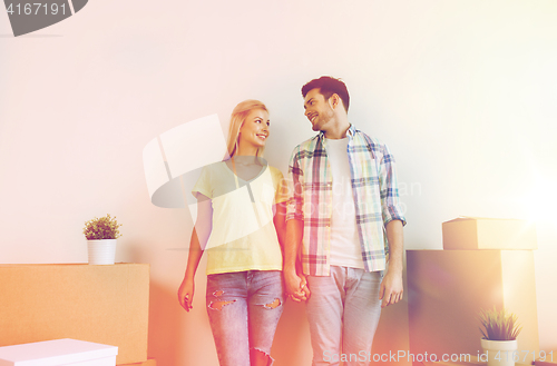 Image of smiling couple with big boxes moving to new home