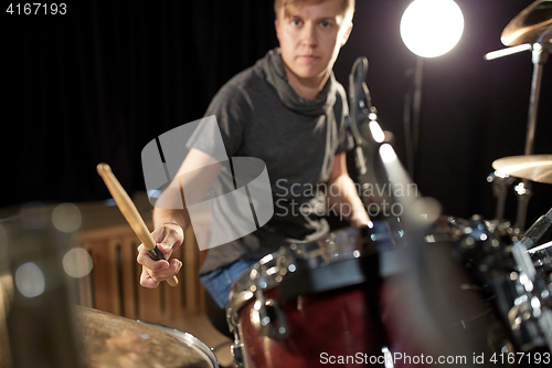 Image of male musician playing drums and cymbals at concert