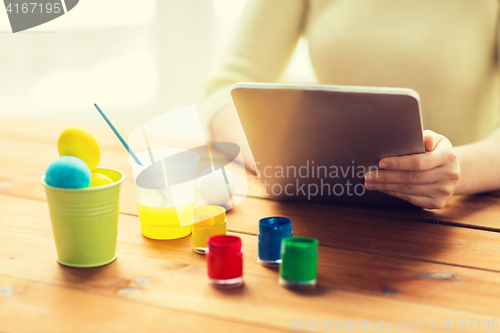 Image of close up of woman with tablet pc and easter eggs