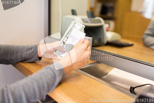 Image of customer with money and receipt at bank counter