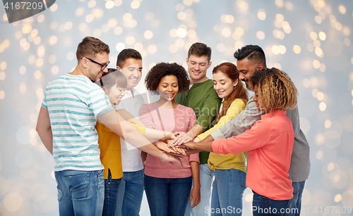 Image of international group of happy people holding hands