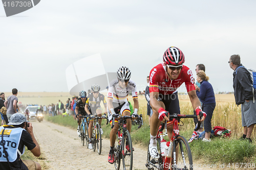 Image of Group of Cyclists Riding on a Cobblestone Road - Tour de France 