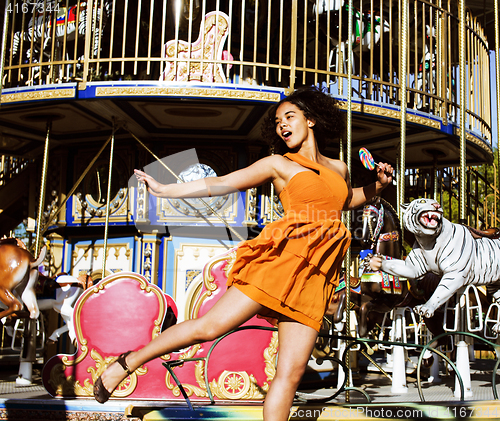 Image of teenage with candy near carousels